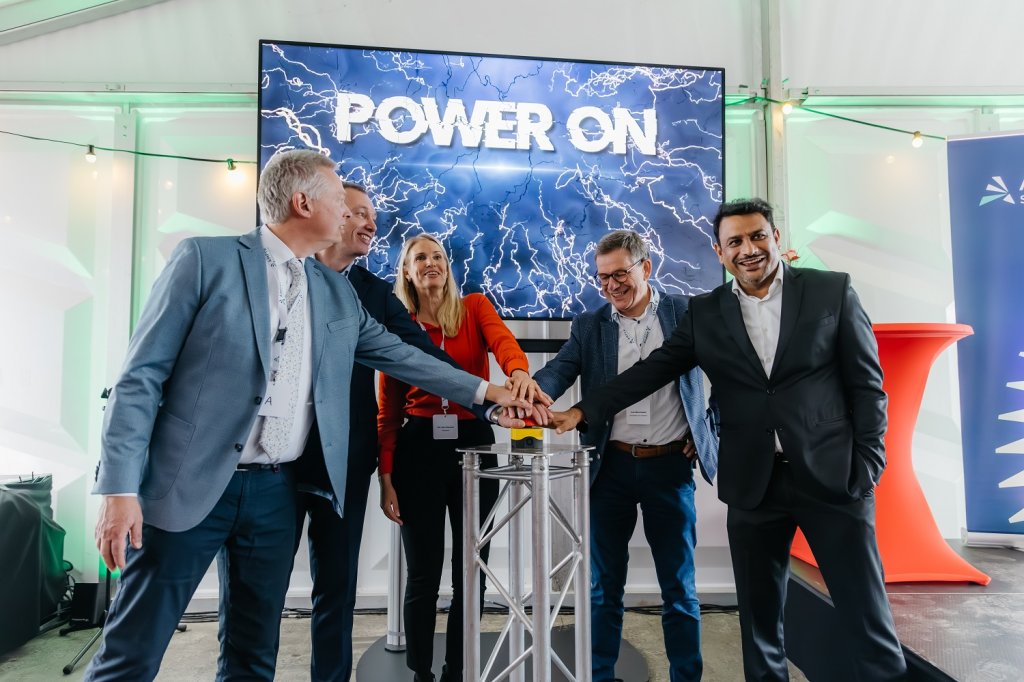 Wethouder Hub Meuwissen opent met nog enkele andere betrokkenen met een druk op een rode knop het zonnepark Groensebos