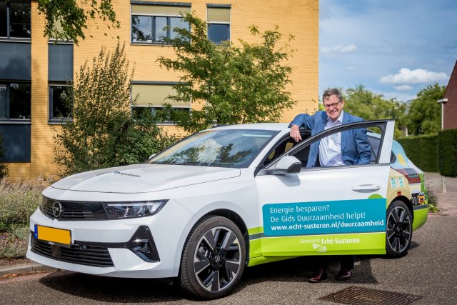 Wethouder Hub Meuwissen bij elektrische auto van Gids Duurzaamheid