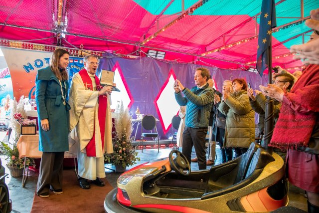 Pastoor met wethouder Kim Leurs en enkele mis-bezoekers op de botsautobaan