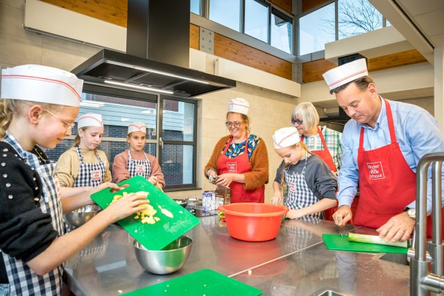 Kinderen en wethouder Geert Frische koken samen in de KinderKOOKschool