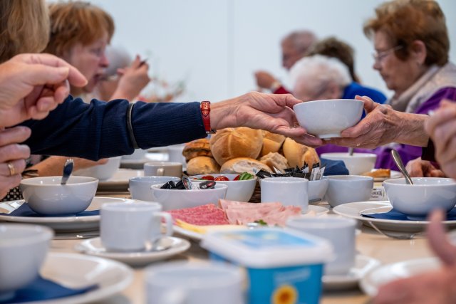 Een gedekte tafel met enkele deelnemers aan de verbindingslunch