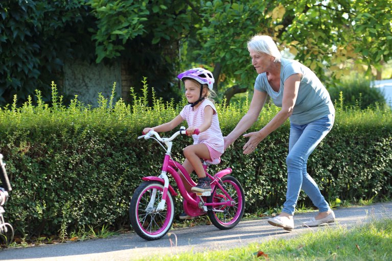 Meisje op de fiets met oma