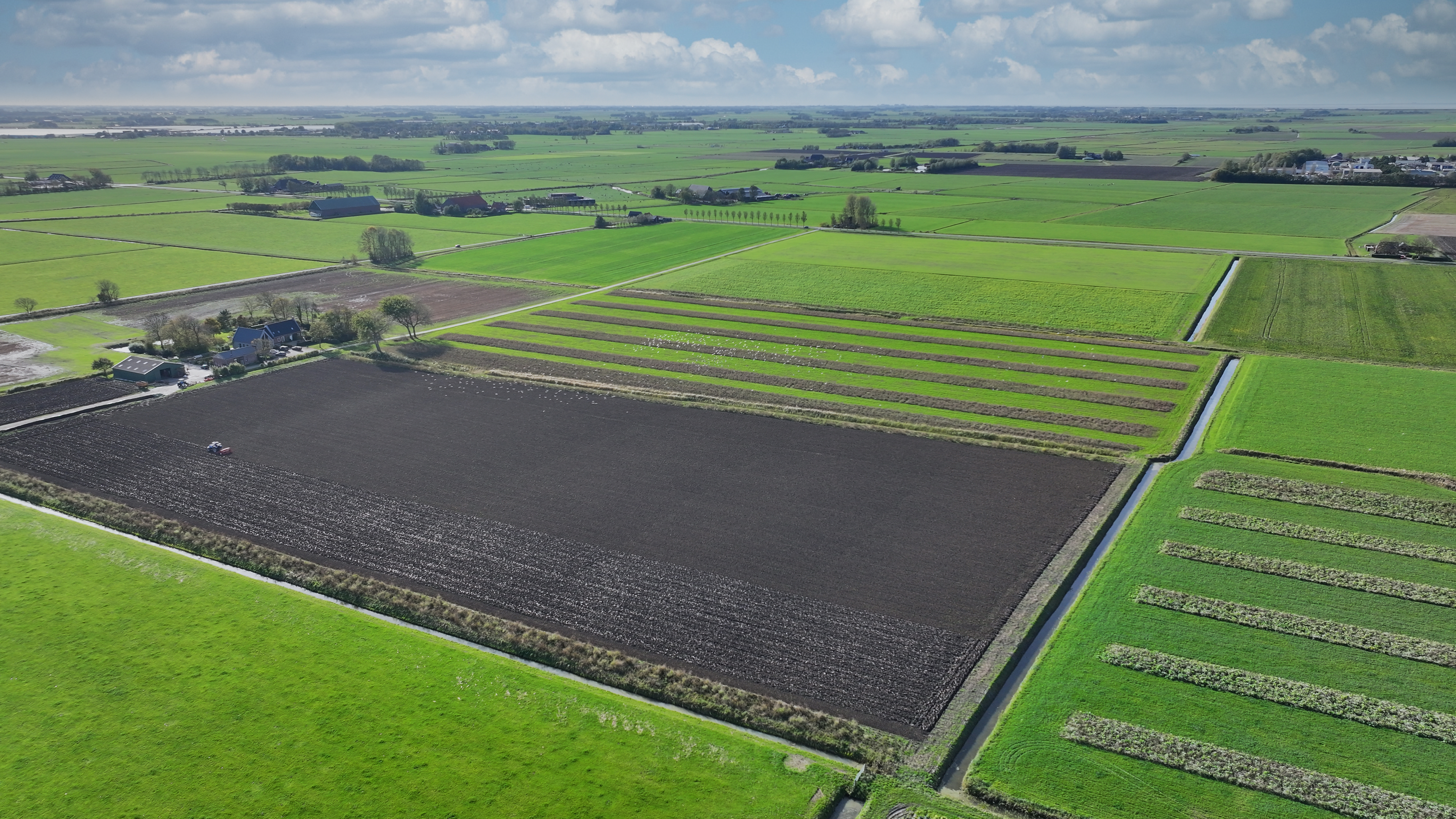 Een foto vanuit een drone gemaakt van St. Annaparochie Noord-West. Weilanden en akkergrond.