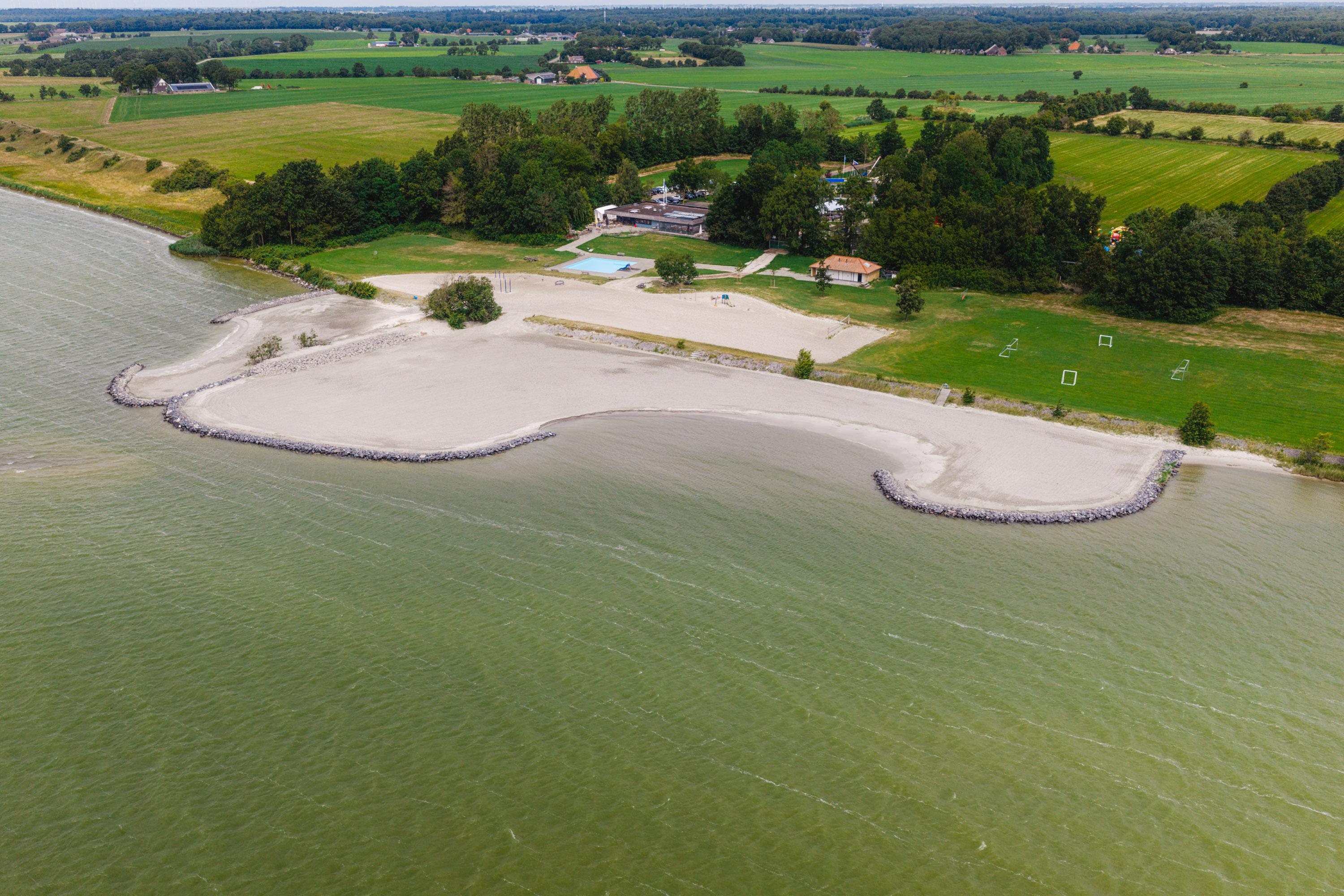 Een strand aan een groene omgeving.