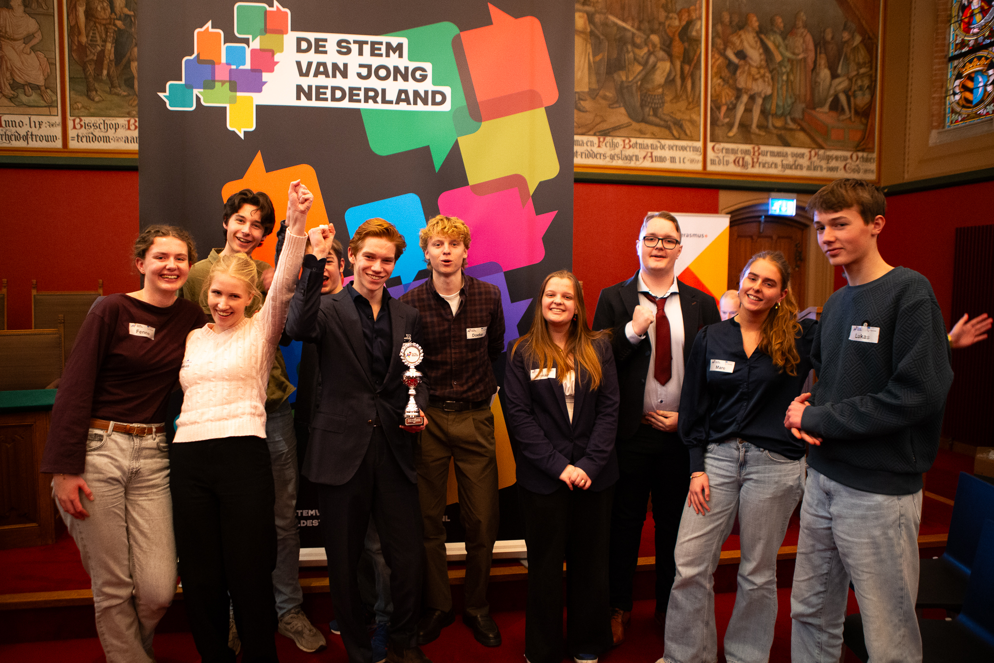 Een groep jongeren staan in de Statenzaal te juichen.