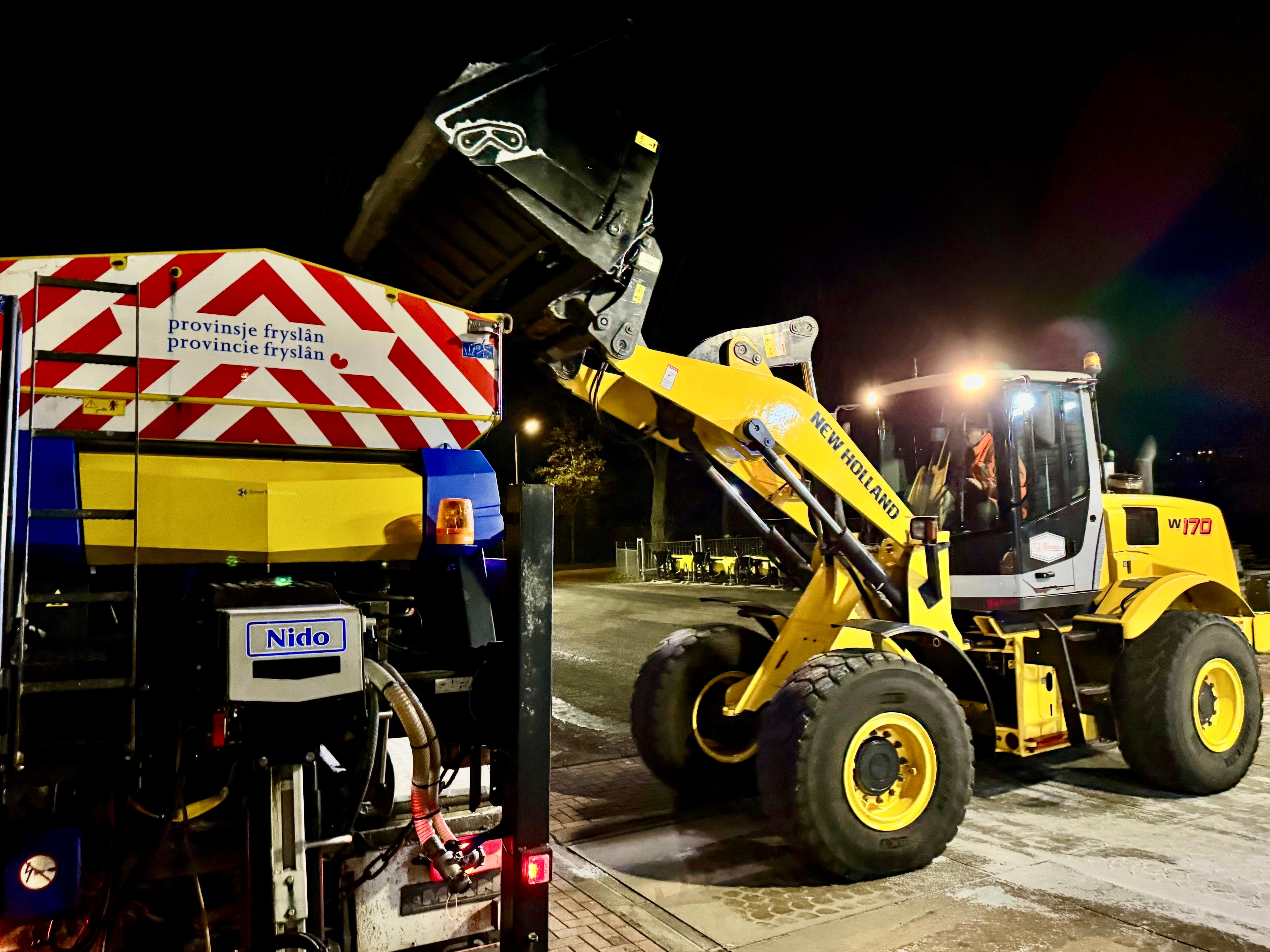 Een shovel is zout aan het scheppen uit een container.