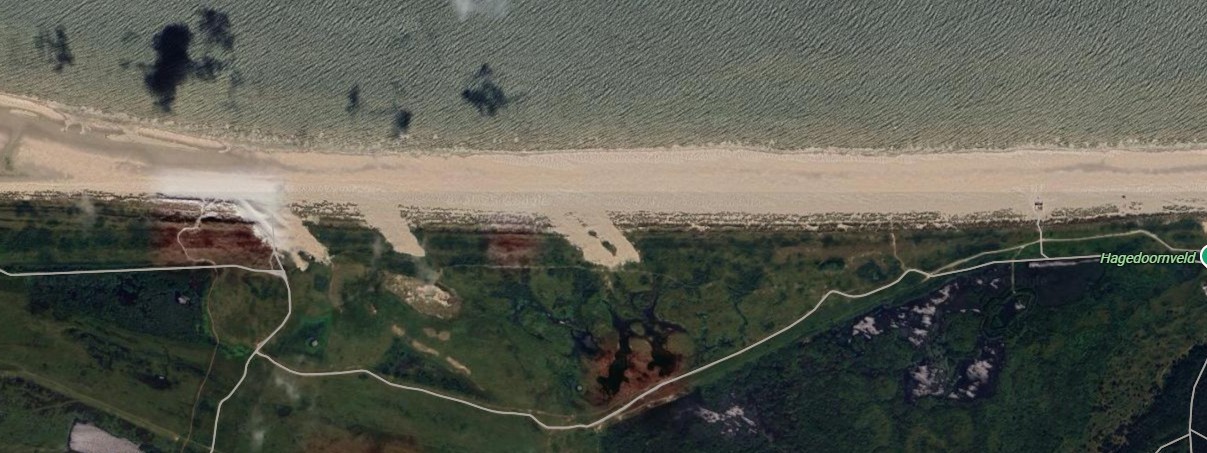 Een bovenaanzicht van het strand en de kerven op Ameland.