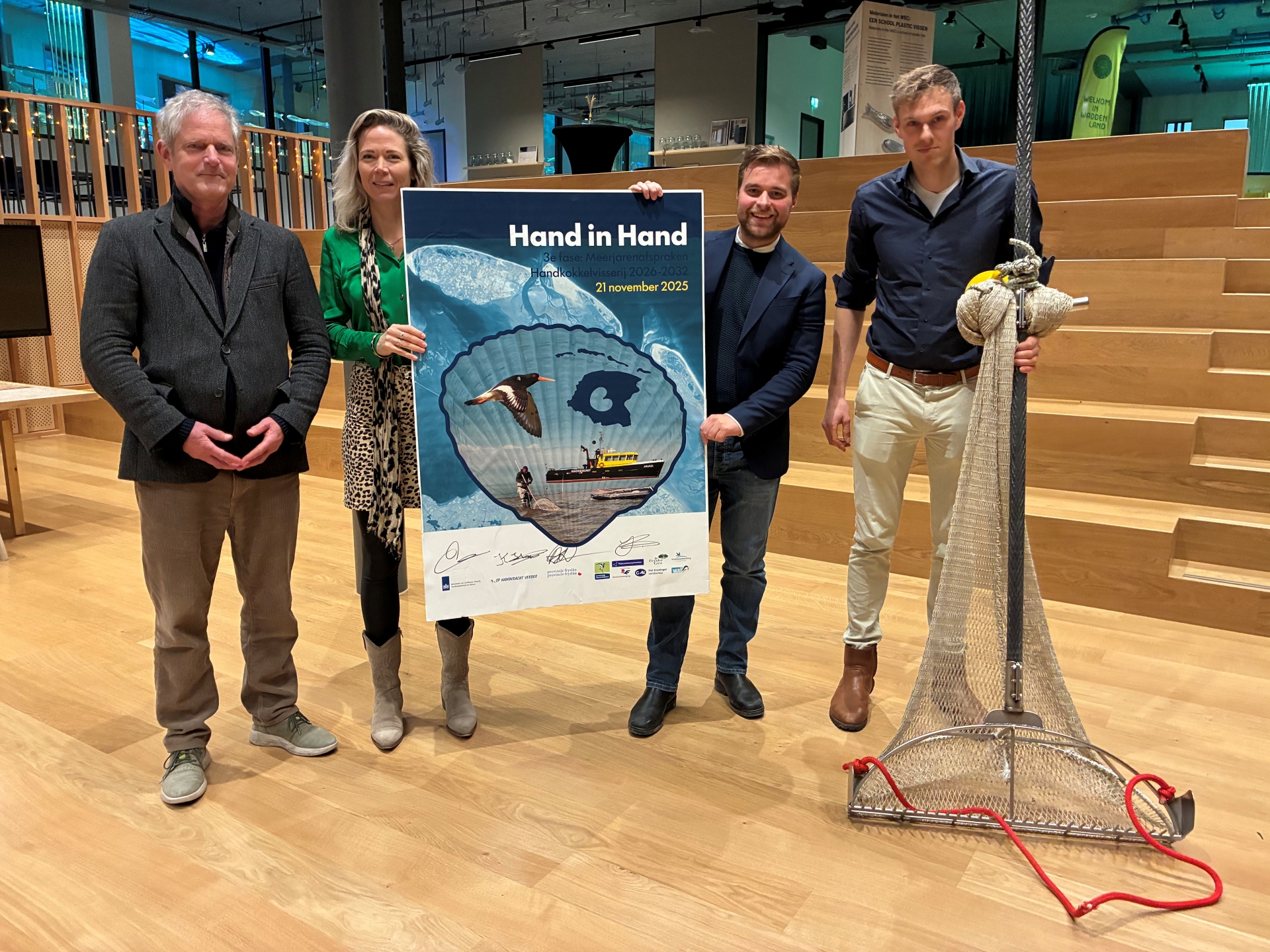 foto van de ondertekening met Bram Streefland (ministerie LVVN), Jorien Bakker (Coalitie Wadden Natuurlijk), Abel Kooistra (gedeputeerde Provincie Fryslân) en Kevin Hout (handkokkelvisser en bestuurslid Op Handkracht Verder).