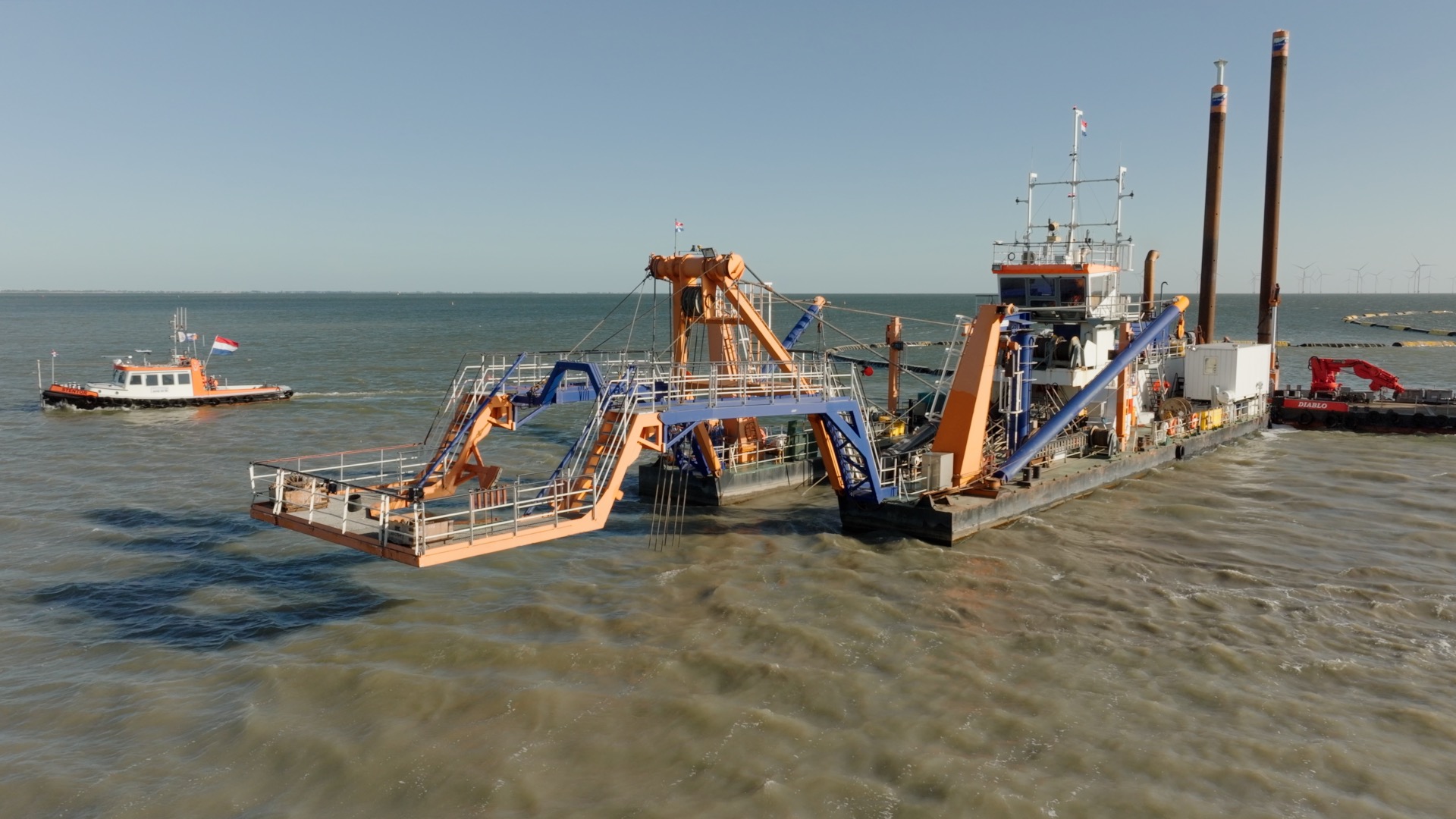 Een grote machine (deze heet een snijkopzuiger) op het water.