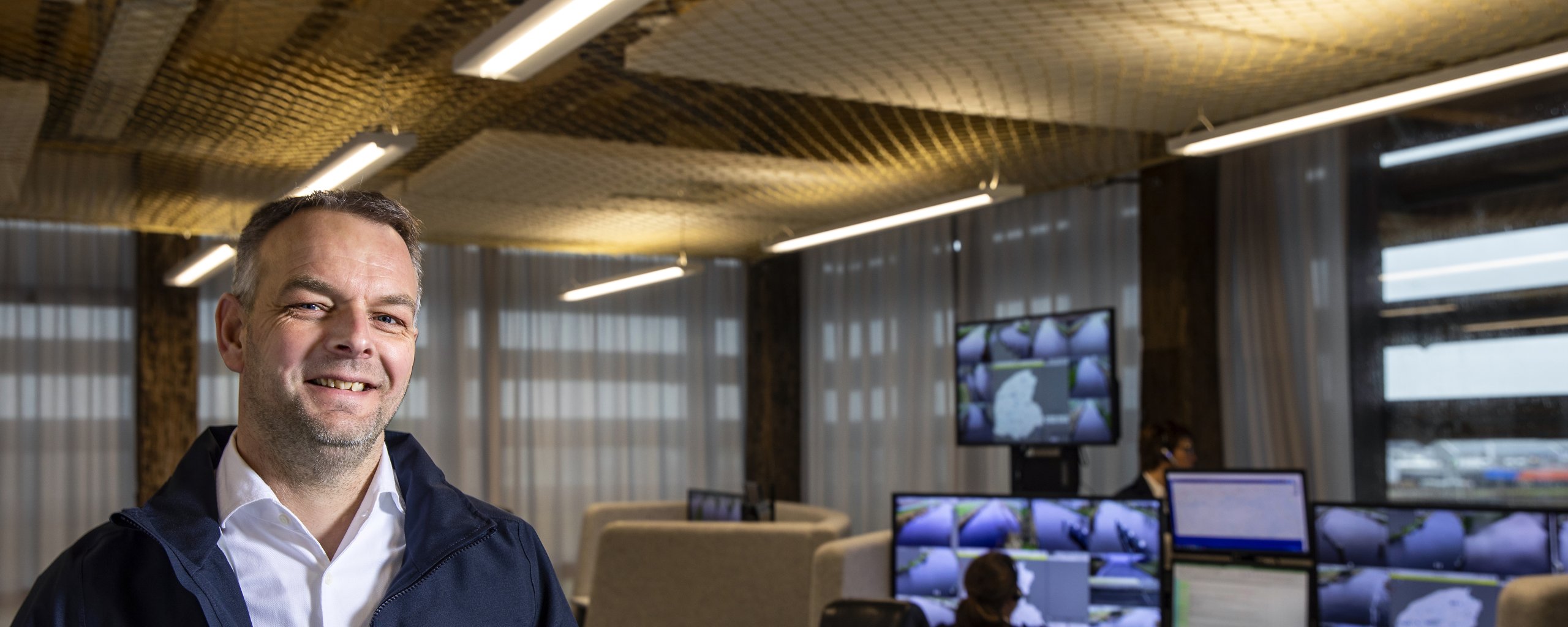 Een man staat in de ruimte waar de bruggen op afstand bediend worden.