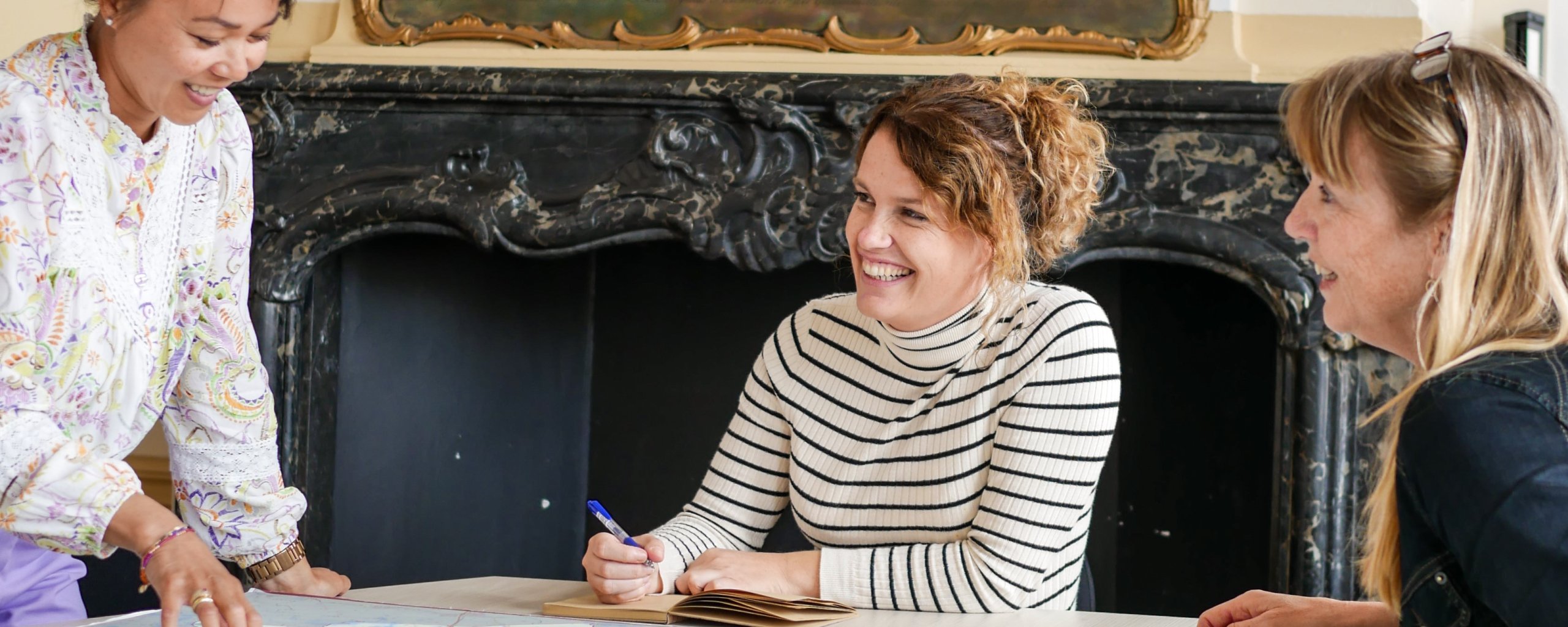 Drie personen hebben overleg aan tafel
