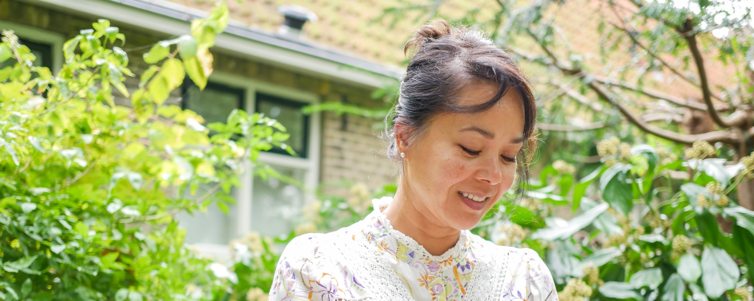 Een vrouw zit te lezen op een muurtje