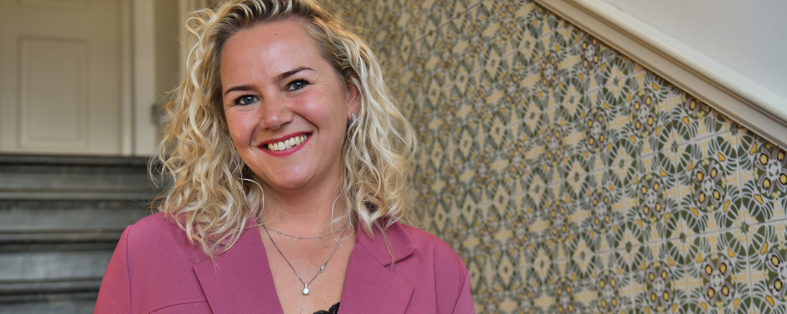 Vrouw met een brede glimlach op een trap