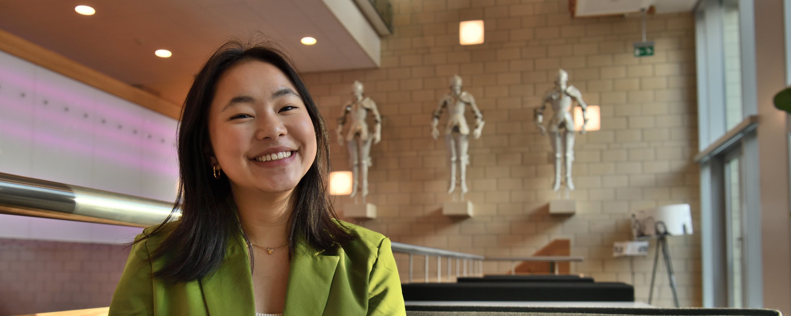 Een vrouw zit in de publiekshal van het provinciehuis