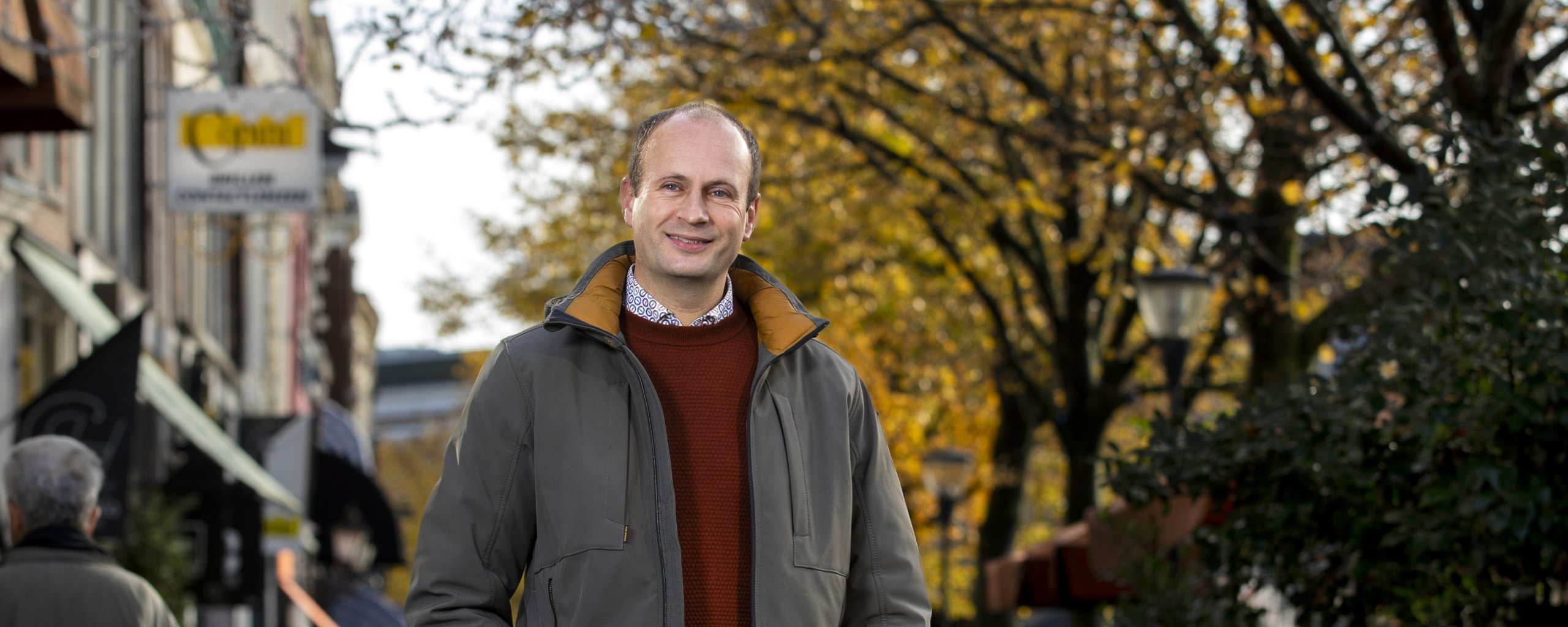 Een man staat te poseren in een winkelstraat in Leeuwarden.