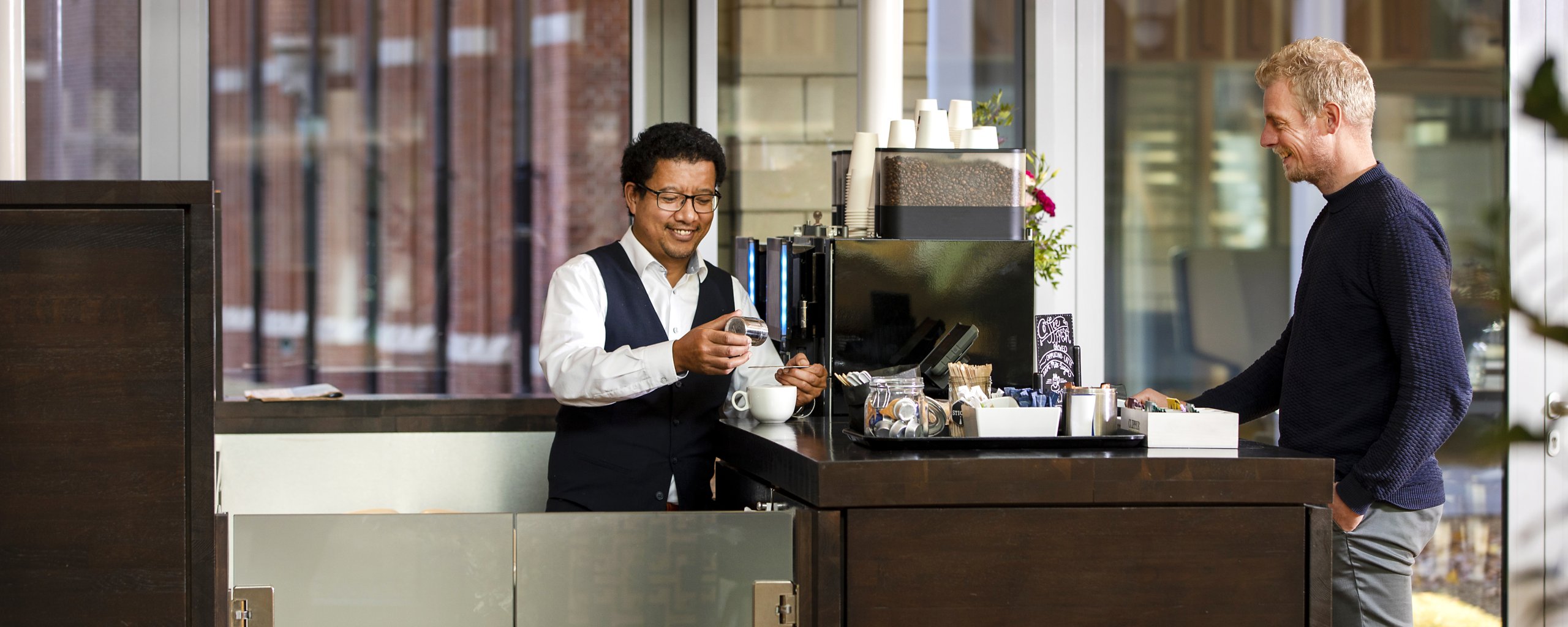 Er staat een man koffie te maken voor een collega uit het provinciehuis