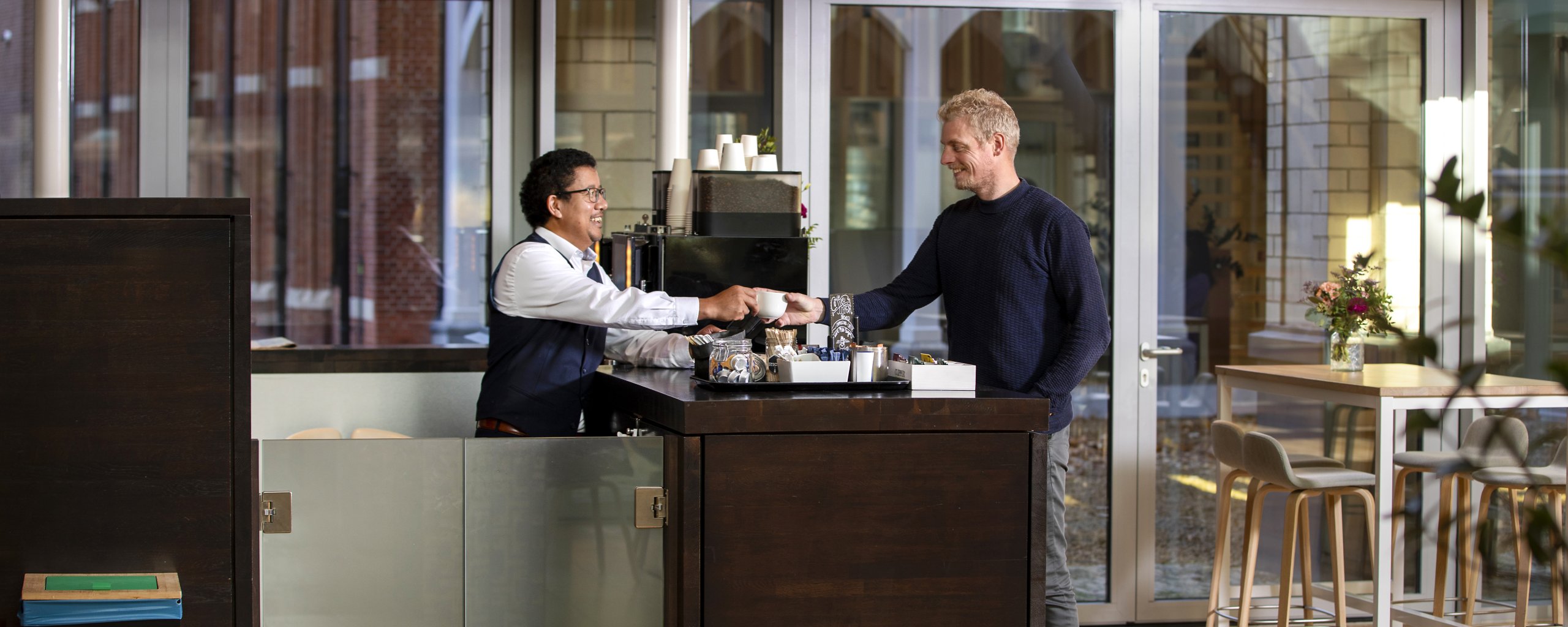 Een man haalt een kop koffie bij de koffiebar in het provinciehuis.