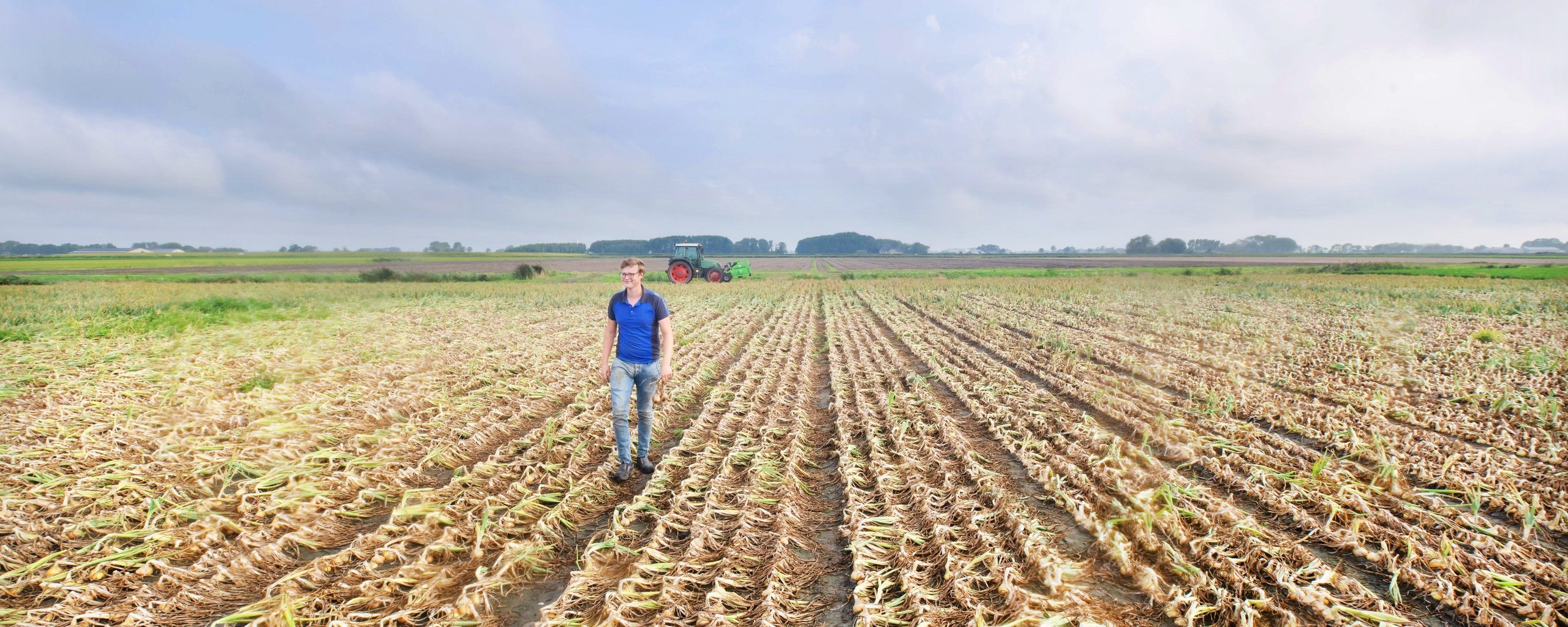 Een man loopt door een akker.