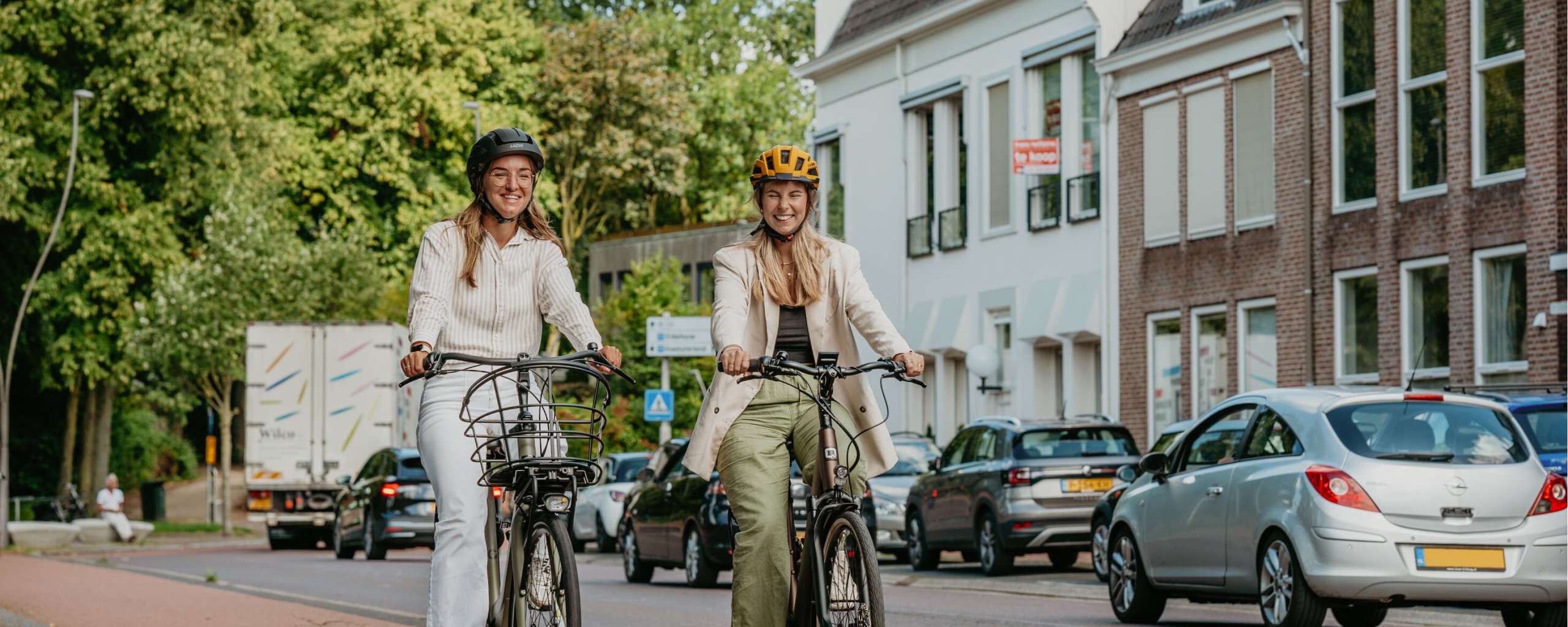 Twee jonge vrouwen fietsen met een fietshelm op