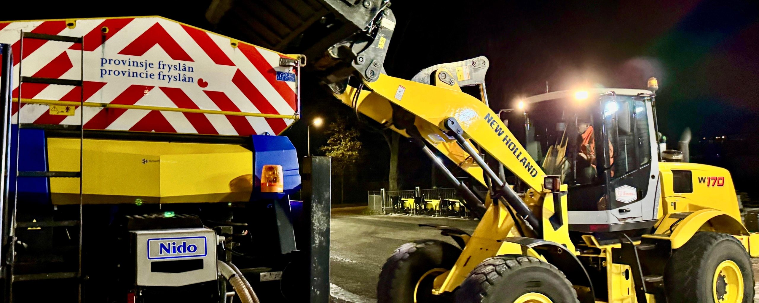 Een shovel is zout aan het scheppen uit een container.