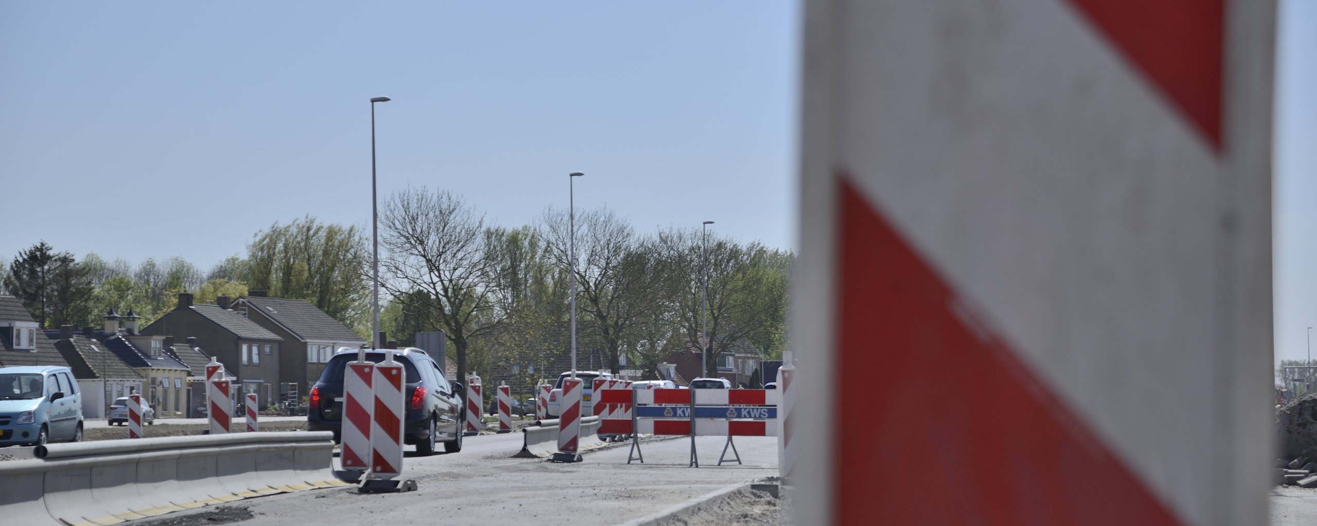 Een weg waar aan gewerkt wordt en waar waarschuwingshekken staan.