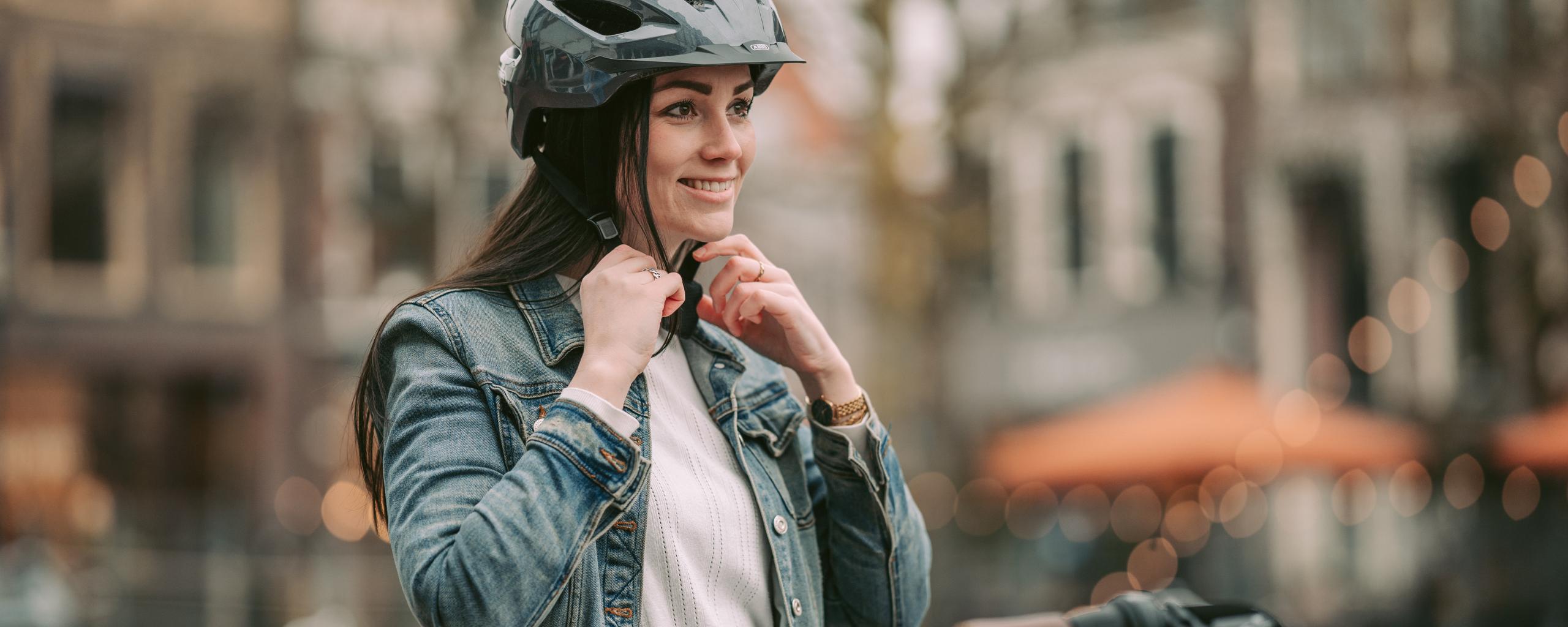 Een jonge vrouw op de fiets met een fietshelm op