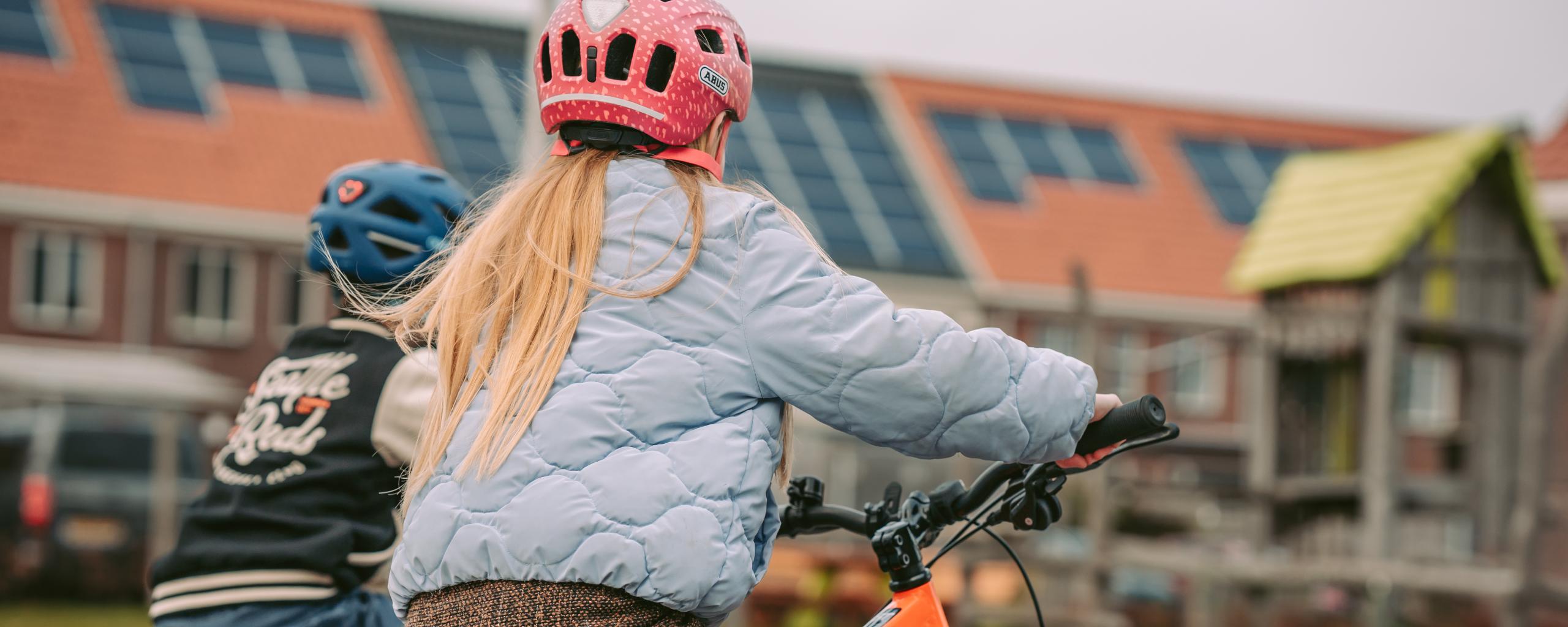 Kinderen fietsend met een helm op