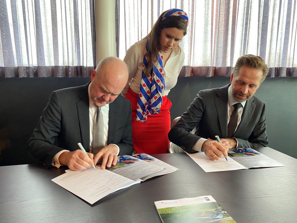 Commissaris van de Koning Brok en minister Hugo de Jonge tekenen de bestuursafspraak onder toezicht van gedeputeerde Eke Folkerts.
