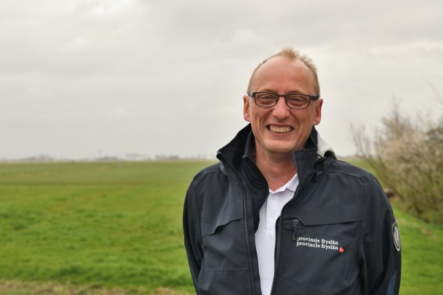 Collega Marten Kalsbeek met een weiland op de achtergrond
