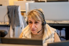 Jelly Bosma met een headset op achter de computer.
