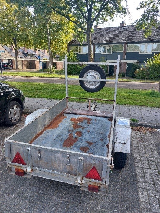 Een open aanhanger met reserve wiel