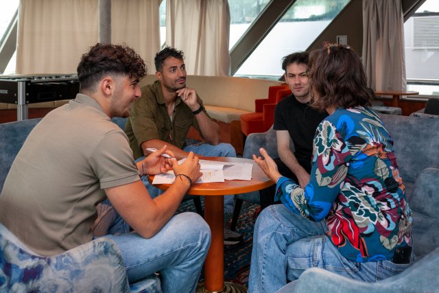 Stockfoto van 3 jongens en 1 vrouw die bezig zijn met Nederlandse les