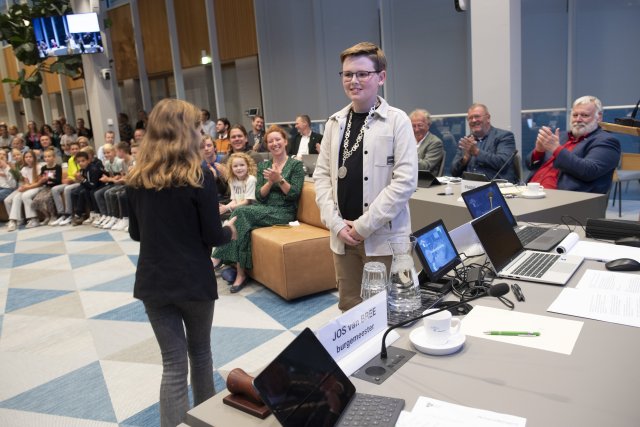 Twee kinderen in een volle raadszaal
