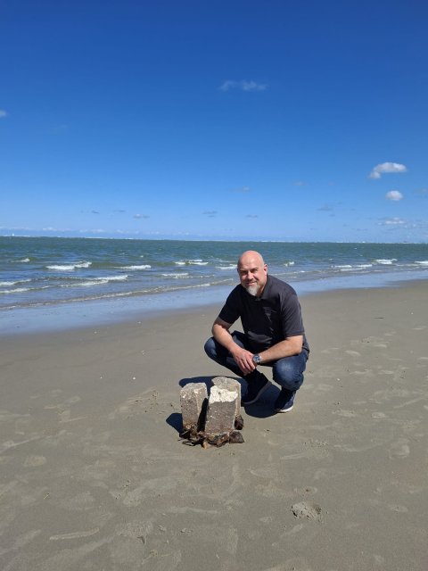 Wethouder Meijroos op het strand bij een vondst