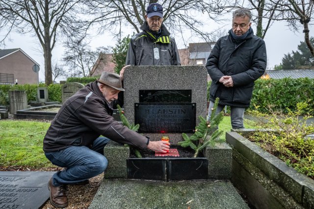 Samen met Dim Geelhoed en Toon Huizer steekt wethouder Henk van Putten het lichtje op het graf van Herbert Austin aan