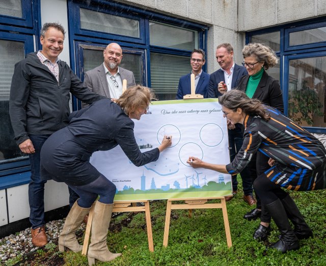Op een grote poster tekenen de architect voor het ontwerp van het nieuwe gemeentehuis