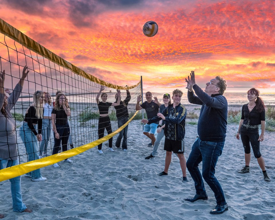 Wethouder Paul Schoute speelt een potje volleybal mee tijdens het laatste strandfeest van dit seizoen.