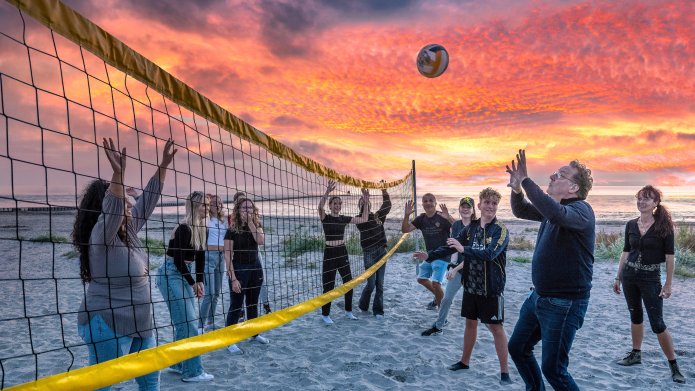 Wethouder Paul Schoute speelt een potje volleybal mee tijdens het laatste strandfeest van dit seizoen.