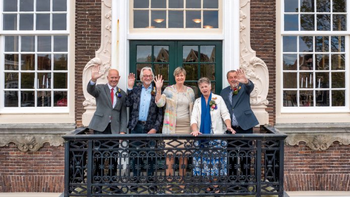 Decoratieve afbeelding met de vier inwoners die een onderscheiding kregen met burgemeester Ina Sjerps. 