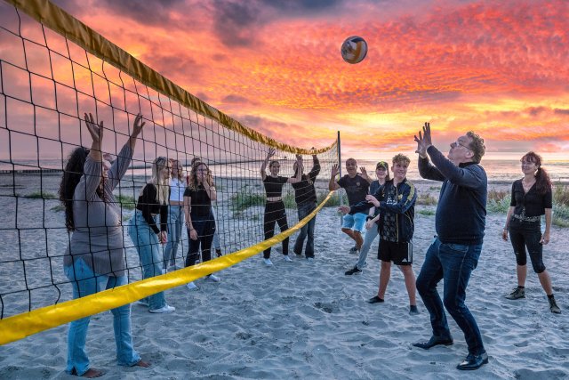 Wethouder Paul Schoute speelt een potje volleybal mee tijdens het laatste strandfeest van dit seizoen.