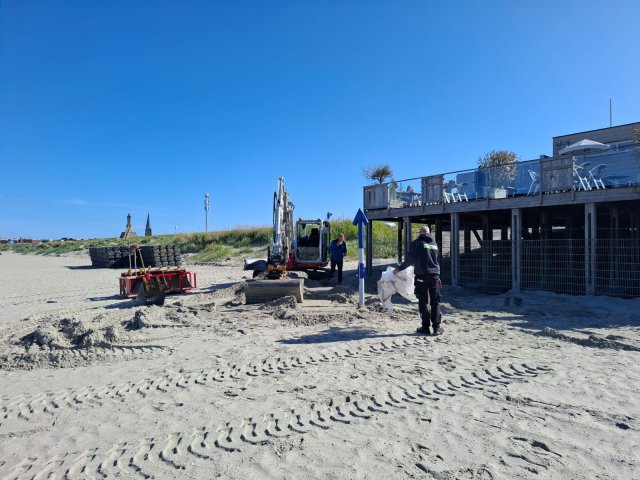 Werknemers bezig met het plaatsen van een stranddouche