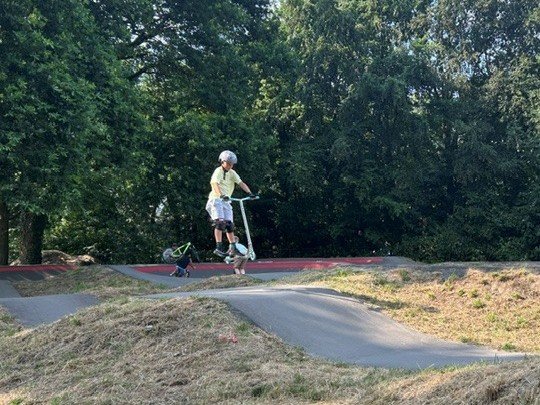 Kind op een stuntstep op een pumptrack