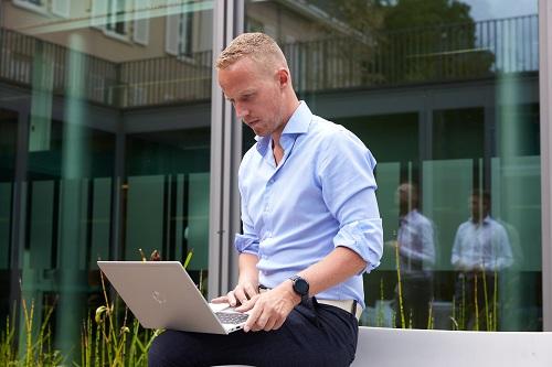 Willem werkt op zijn laptop in de patio van het Cultuurhuis in Doorn