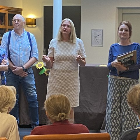 Wethouder Van Werven staat voor de verhalenkar en spreekt de toehoorders aan