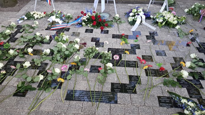 Bloemen zijn neergelegd bij het monument om oorlogsslachtoffers uit Huizen te herdenken