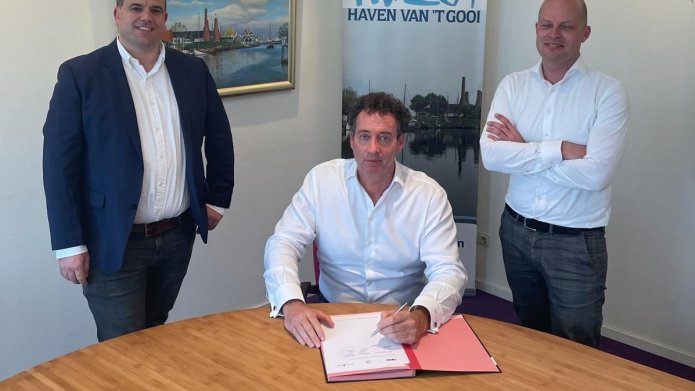 De ondertekening van de contractovername van de Oude Haven Fase 3 door wethouder Roland Boom van de gemeente Huizen, directeur Sjuul Stappers van Verwelius en Michiel de Vries van VORM.