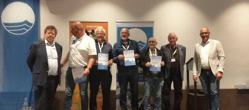 Havenmeester Dick van Veldhuizen en medewerkers van de gemeentelijke haven van Huizen ontvangen de Blauwe Vlag 2025.