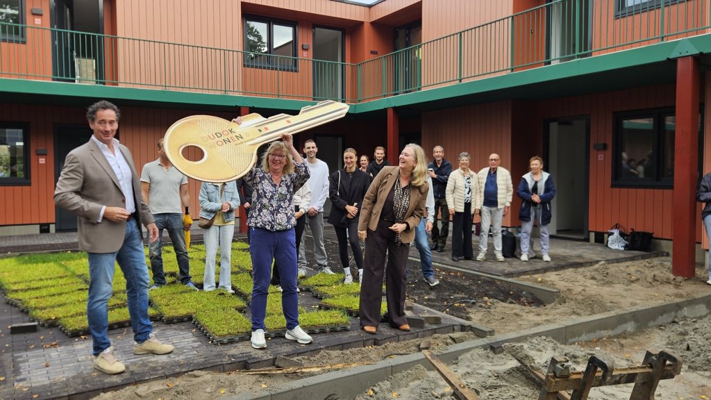 Wethouder Roland Boom, directeur-bestuurder van Dudok Wonen Jacqueline van Ham en projectleider Majolein Ruiters met nieuwe bewoners van de Iephof aan de Trompstraat in Huizen.