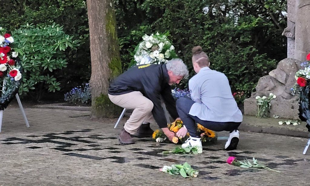 Esmee van het jongerenpanel Huizen en Maarten Janssen van Amnesty leggen een krans tijdens de dodenherdenking.