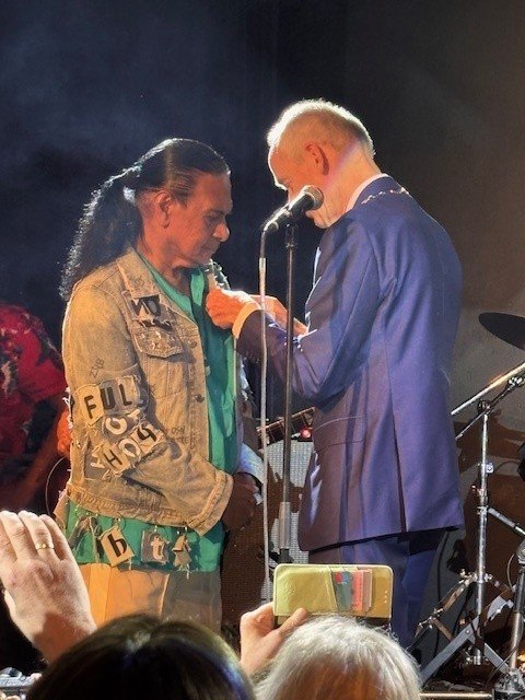 Burgemeester Niek Meijer reikt een koninklijke onderscheiding uit aan Johnny Manuhutu